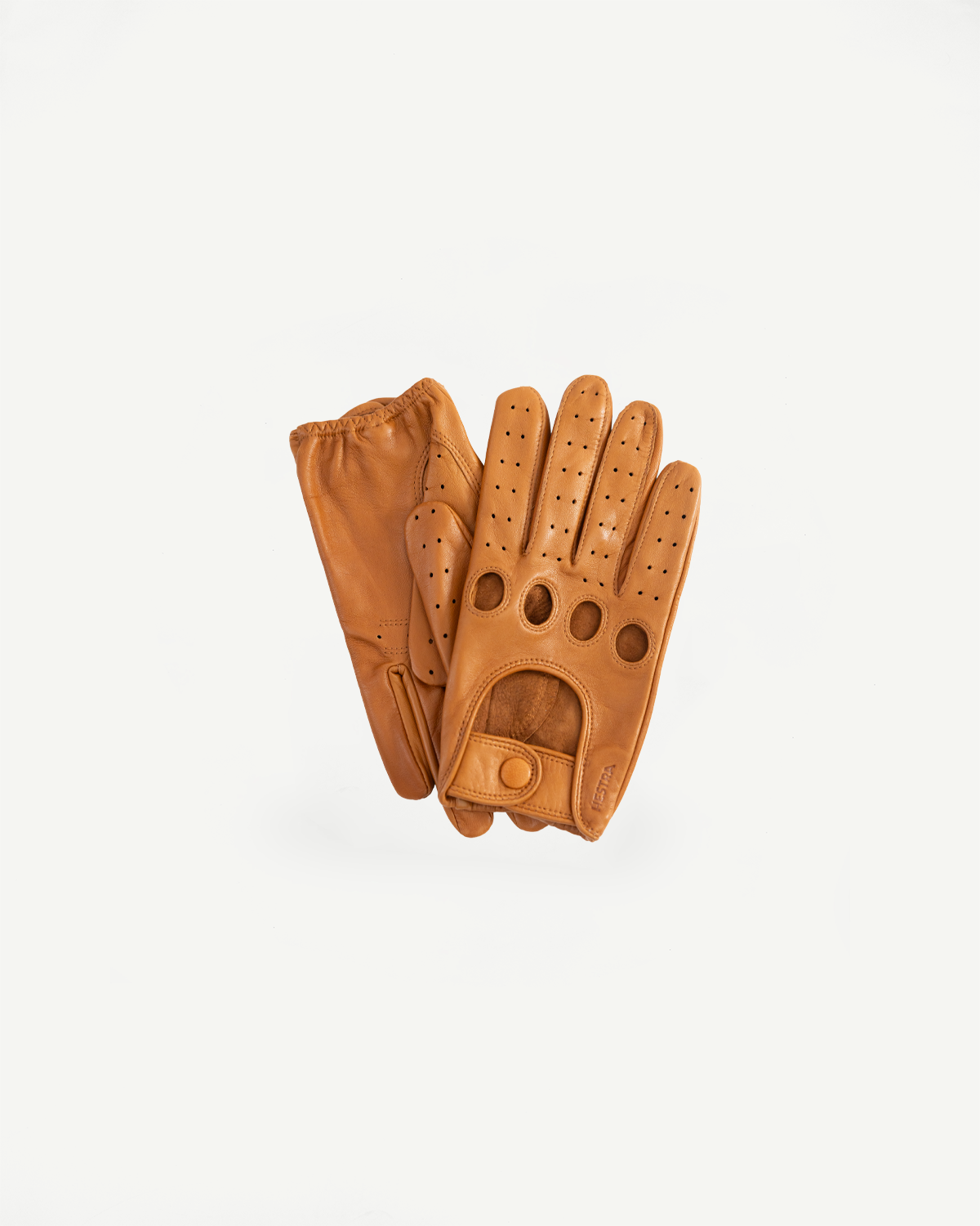 Flat lay front view of tan Hestra Morgan driving gloves, showing perforated leather and snap detail.