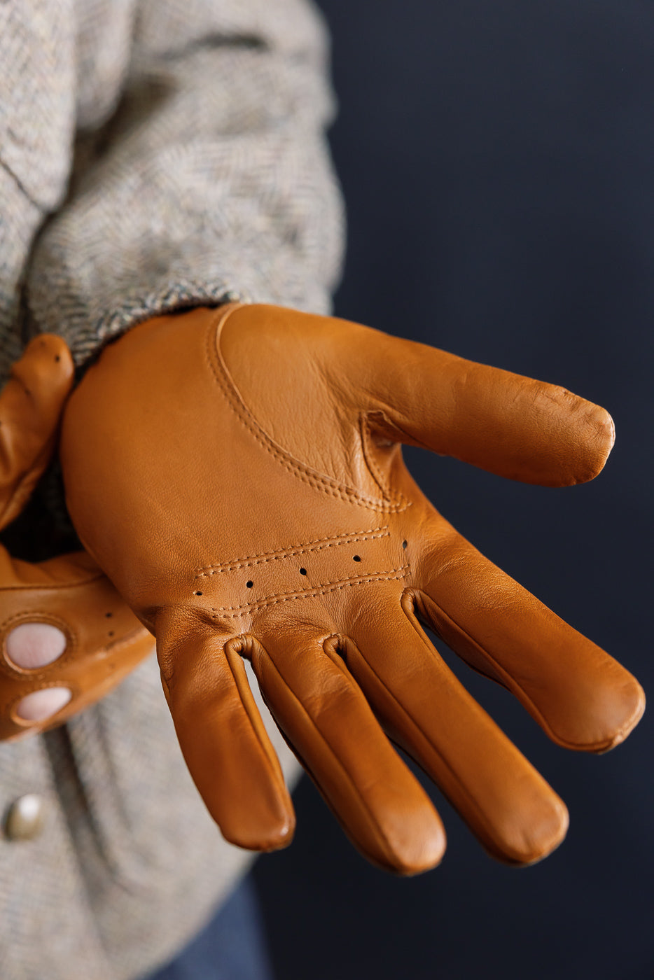 Close-up of male model’s palm in tan Hestra Morgan driving glove, front view, leather texture and stitched details visible