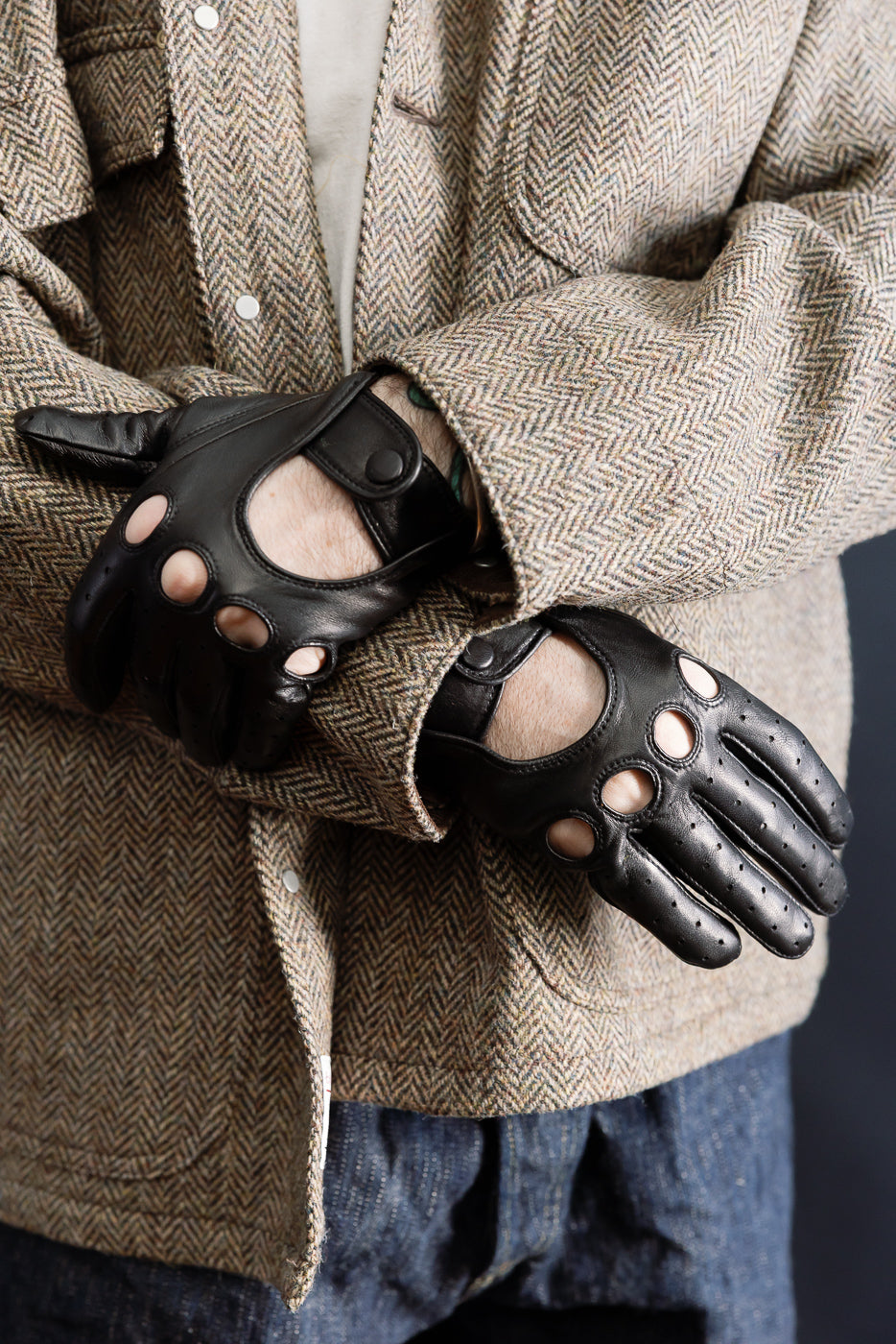 Close-up of black leather driving gloves on male model, 5'9