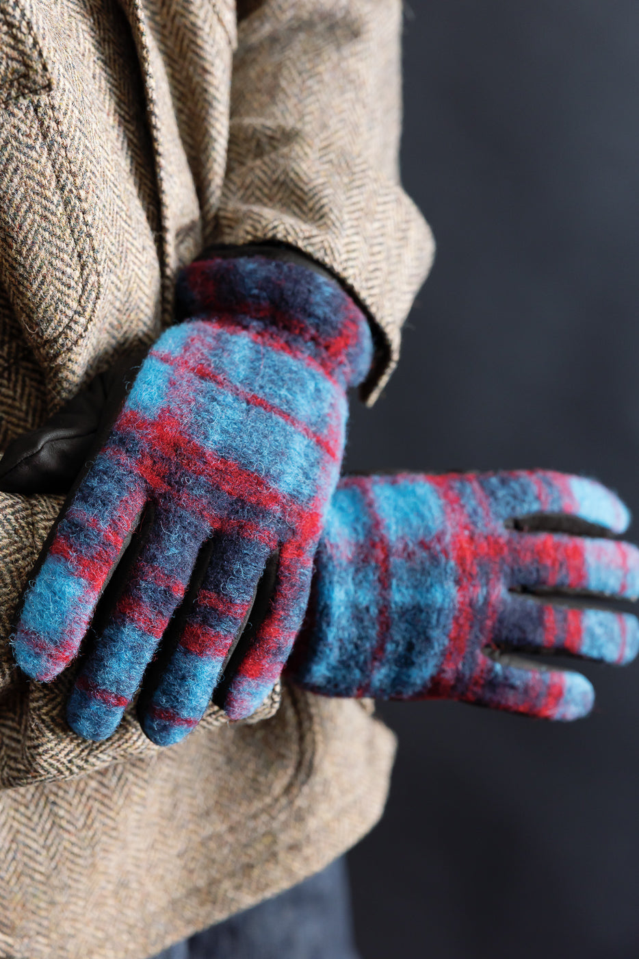 Close-up of Hestra Noah blue and red plaid wool gloves, front view, worn by male model.