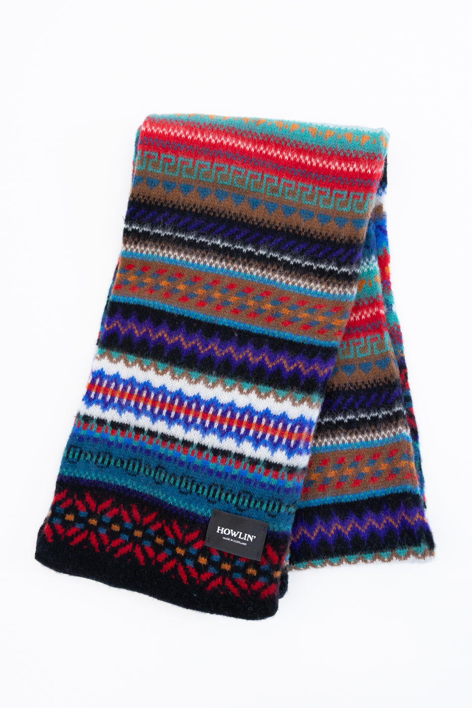 multicolored, patterned wool scarf with a black base on a white background, exposing the back of scarf