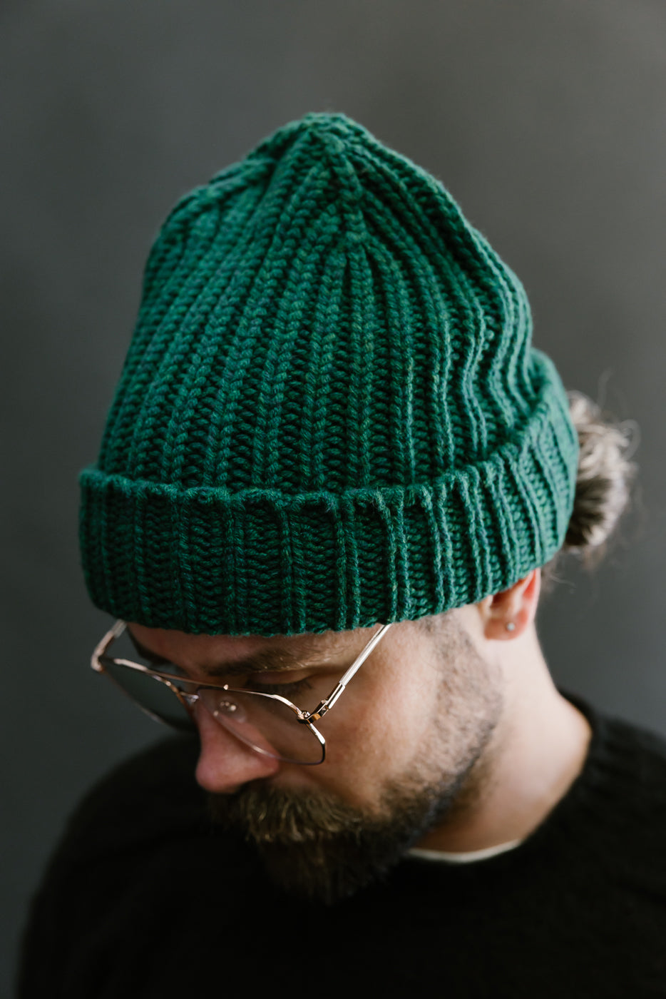 green mix ribbed chunky beanie, watch cap on bearded mans head, close up