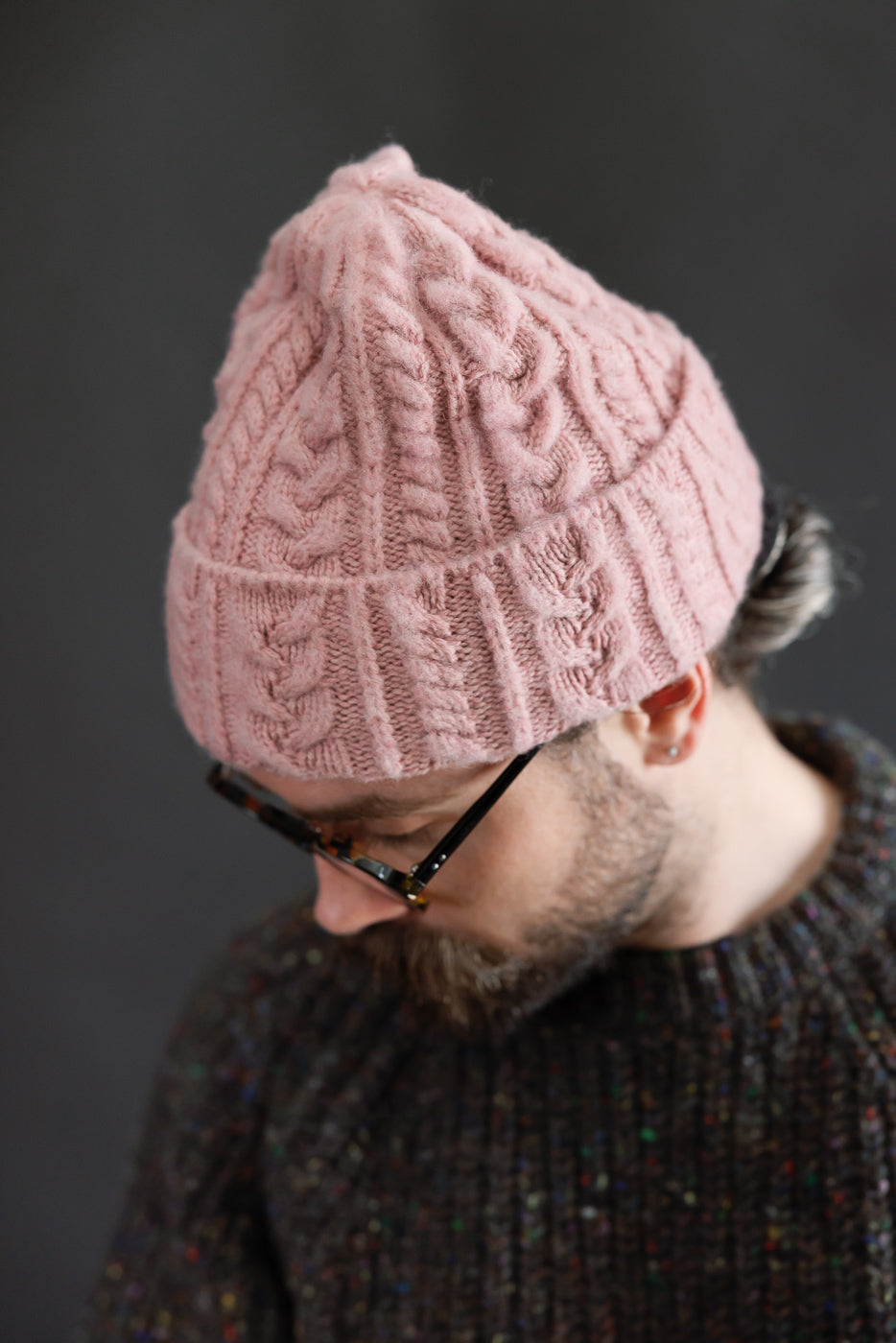 Close-up of soft pink cable knit hat on male model, 5'9