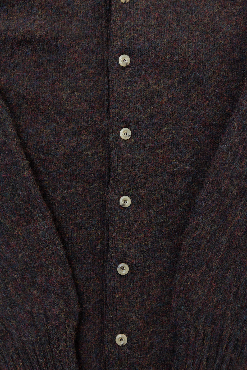 Close-up front of dark wool cardigan, showing textured fabric and button details at Dant.