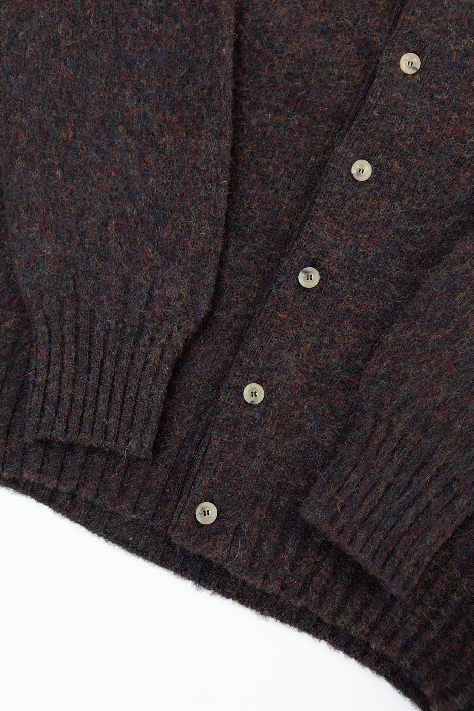 Close-up of front left side of brown wool cardigan with ribbed cuffs, hem, and buttons, Dant