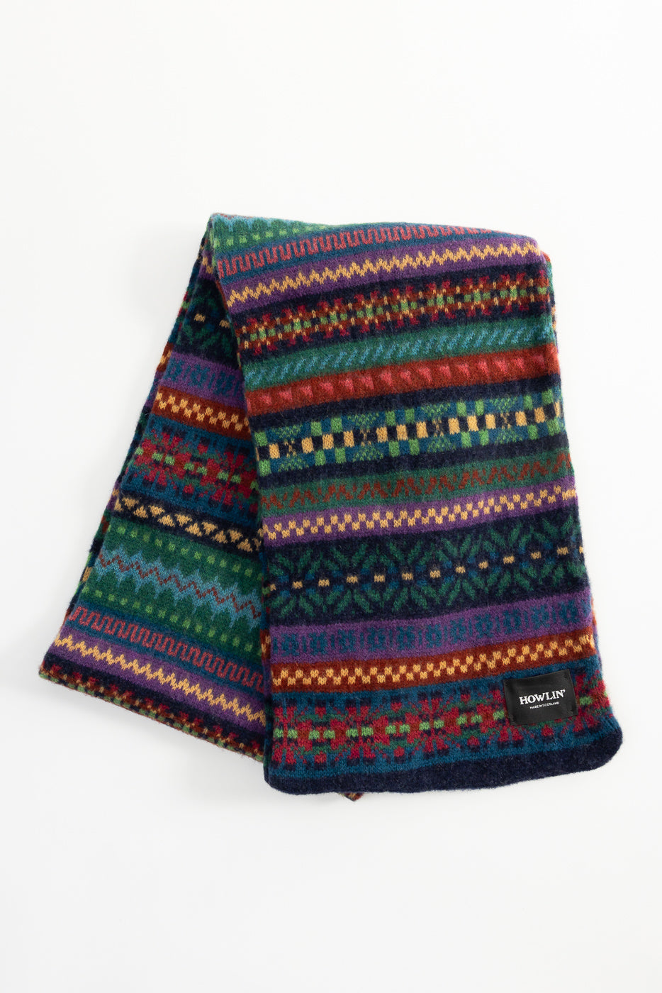 Close-up front flat lay of Howlin' multi-color patterned wool scarf with logo tag, Dant store