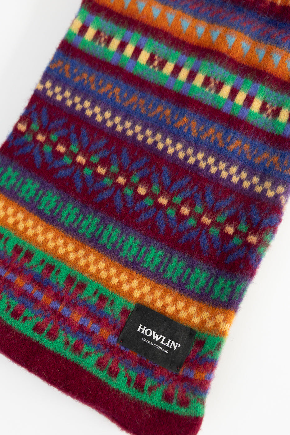 Close-up front view of Howlin' Future Is Mixed Up scarf, colorful knit pattern, visible brand tag.