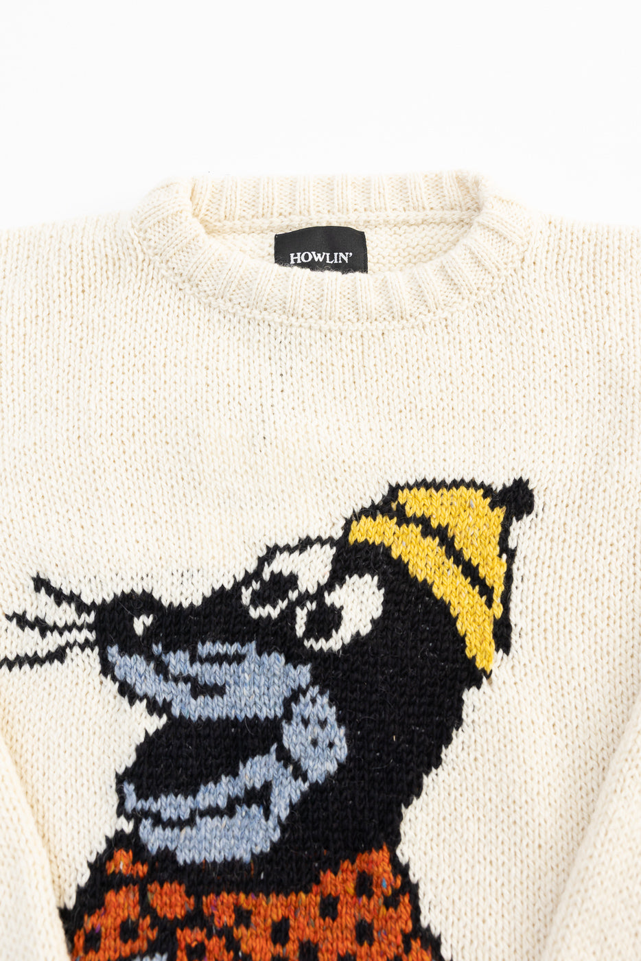 Close-up front of cream Howlin’ sweater, crewneck, with graphic knit rat in yellow hat.