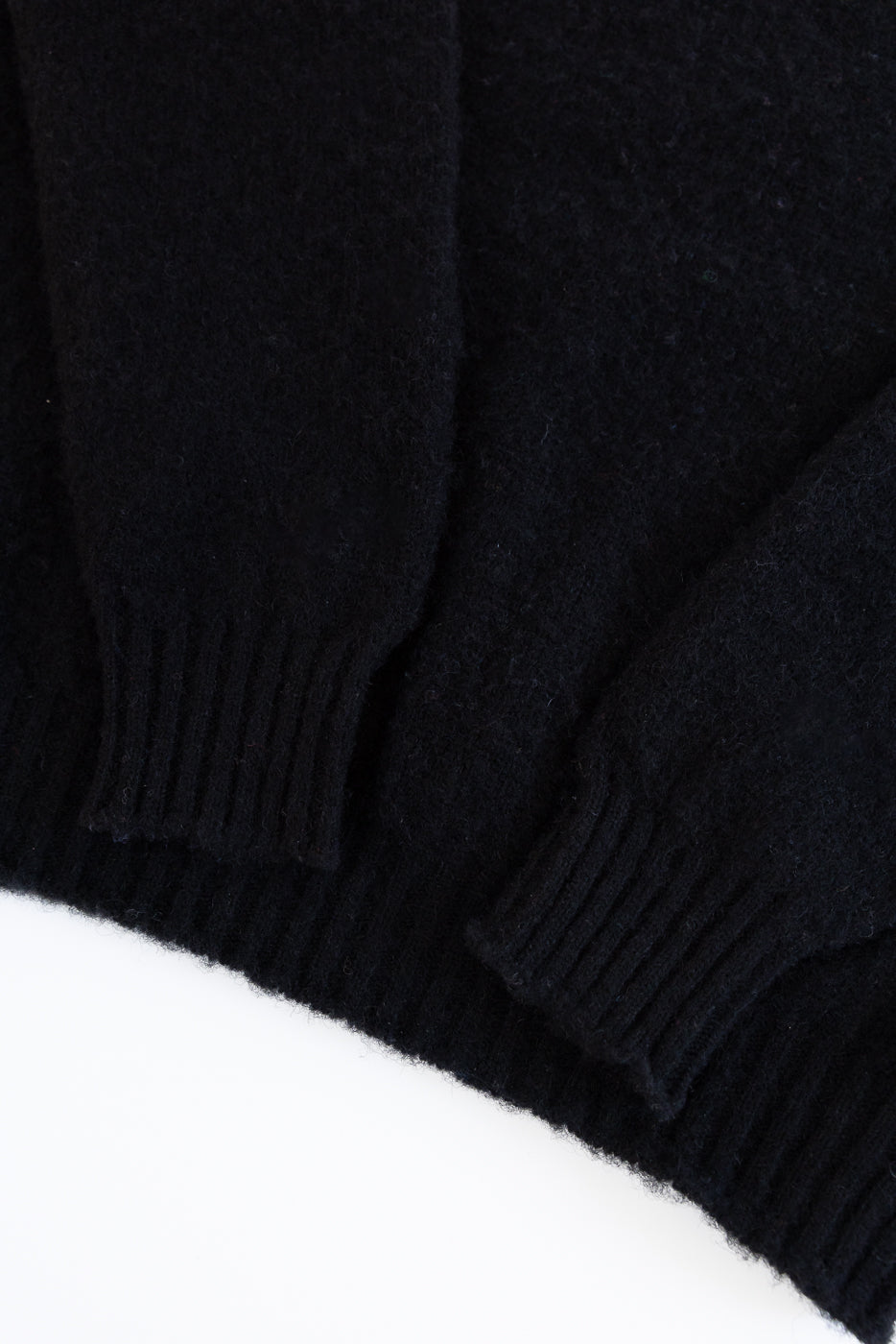 Close-up of a black sweater sleeve on a white background