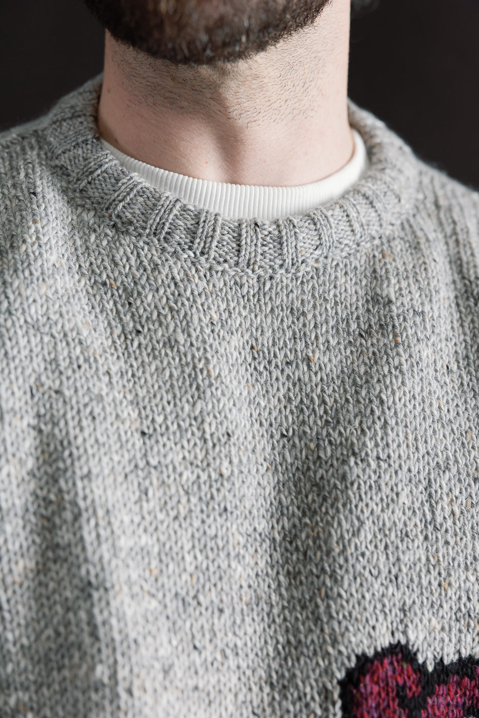 Close-up of male model wearing Howlin Stranger in Paradise silver knit sweater, crew neck detail, front view, athletic build, Dant contemporary casual apparel.