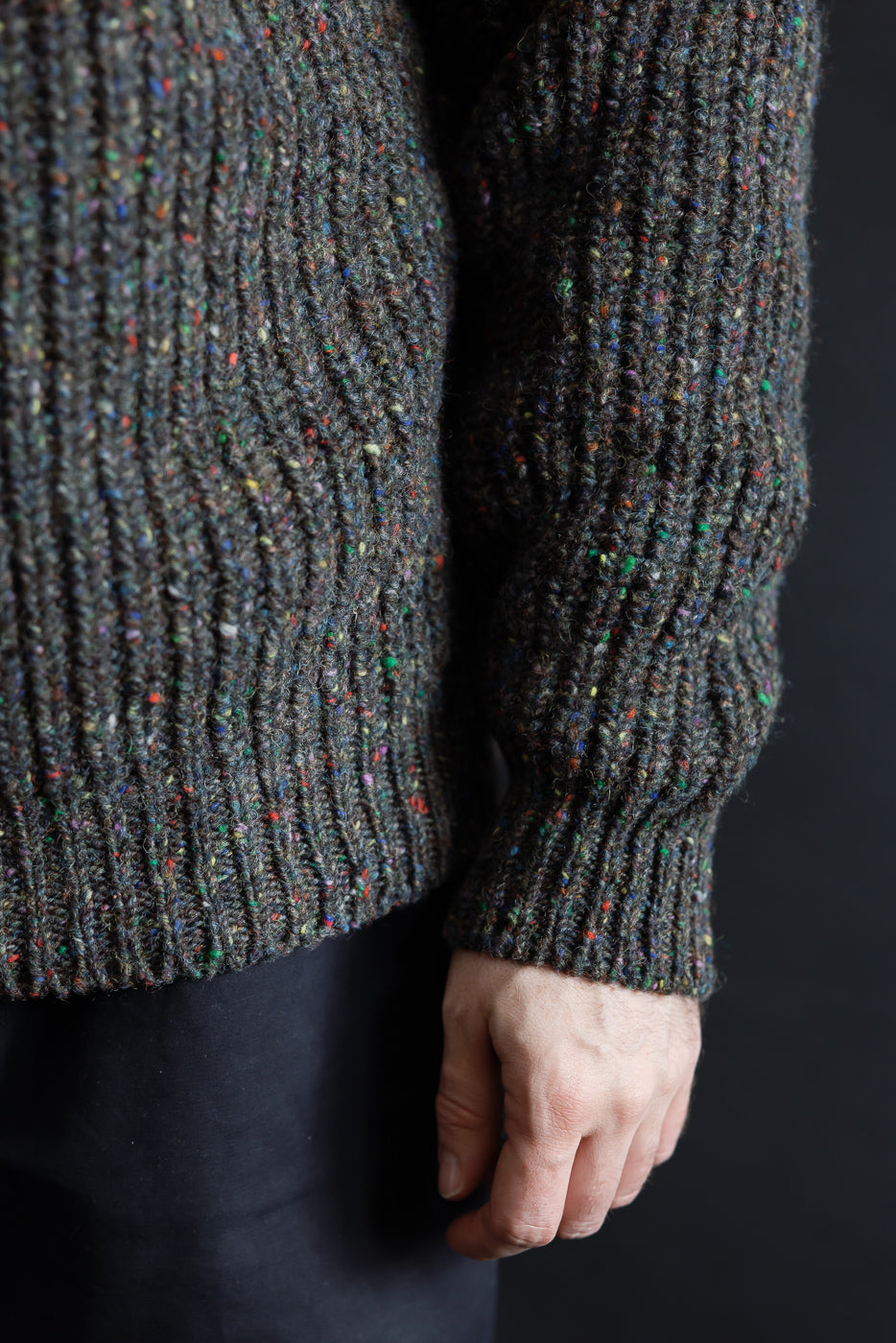 Close-up of male model's right side wearing textured knit speckled pullover by Dant