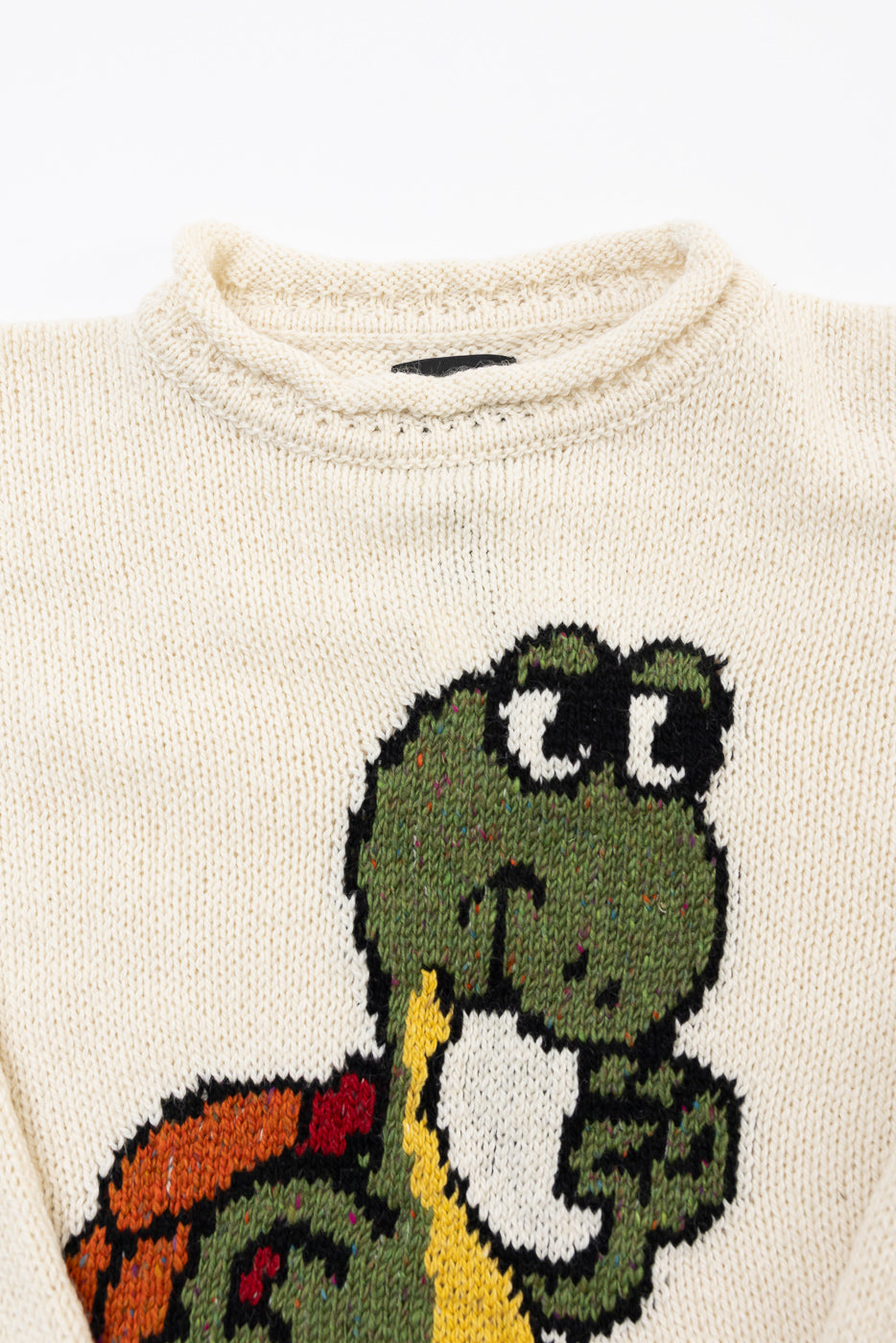 Close-up of front neckline and turtle graphic on ecru knit sweater, Dant apparel