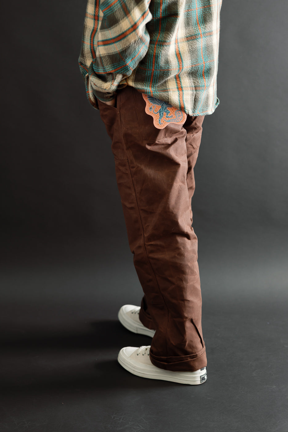 Side view of brown pants on a male model, 5'9