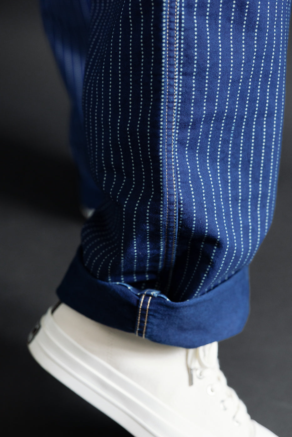 Close-up of cuffed hem on blue dotted selvedge pants, male model 5'9