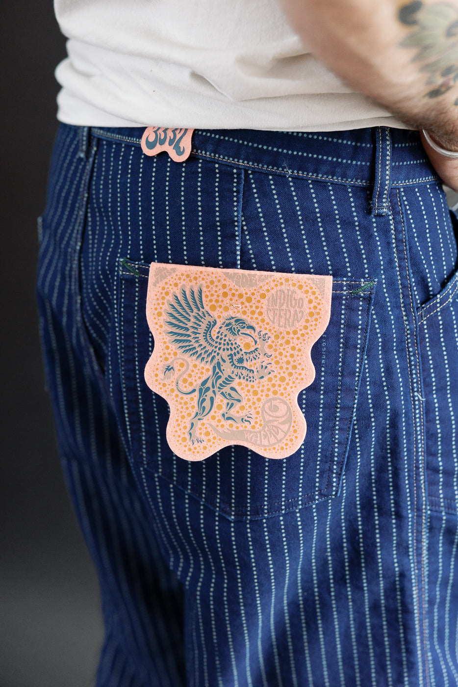 Close-up back view of blue pinstripe jeans on male model, 5'9