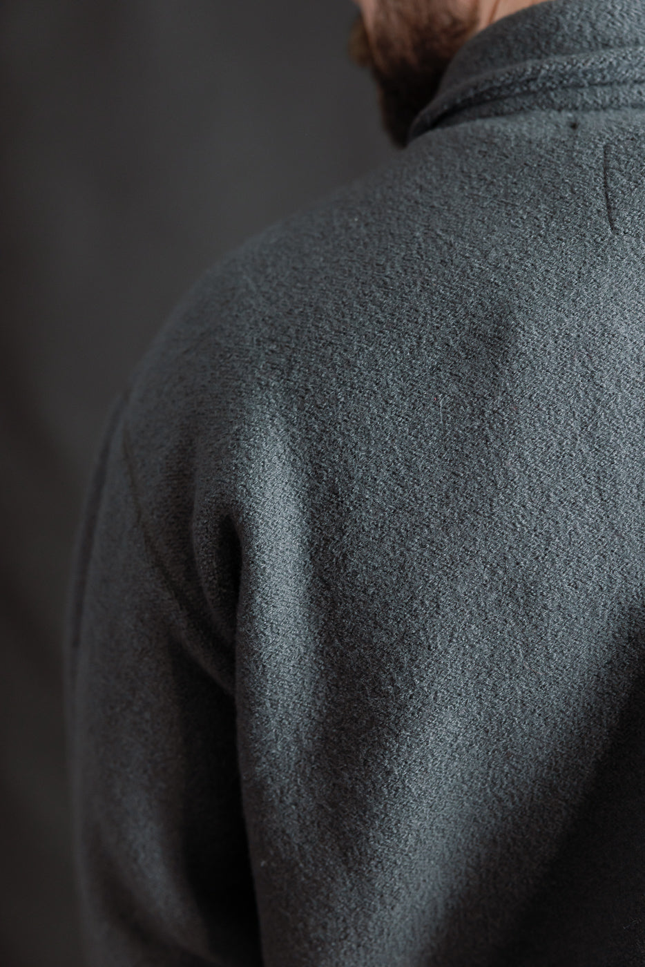 Close-up of dark grey boiled wool Indigofera Brewster shirt, back shoulder texture on male model, 5'9