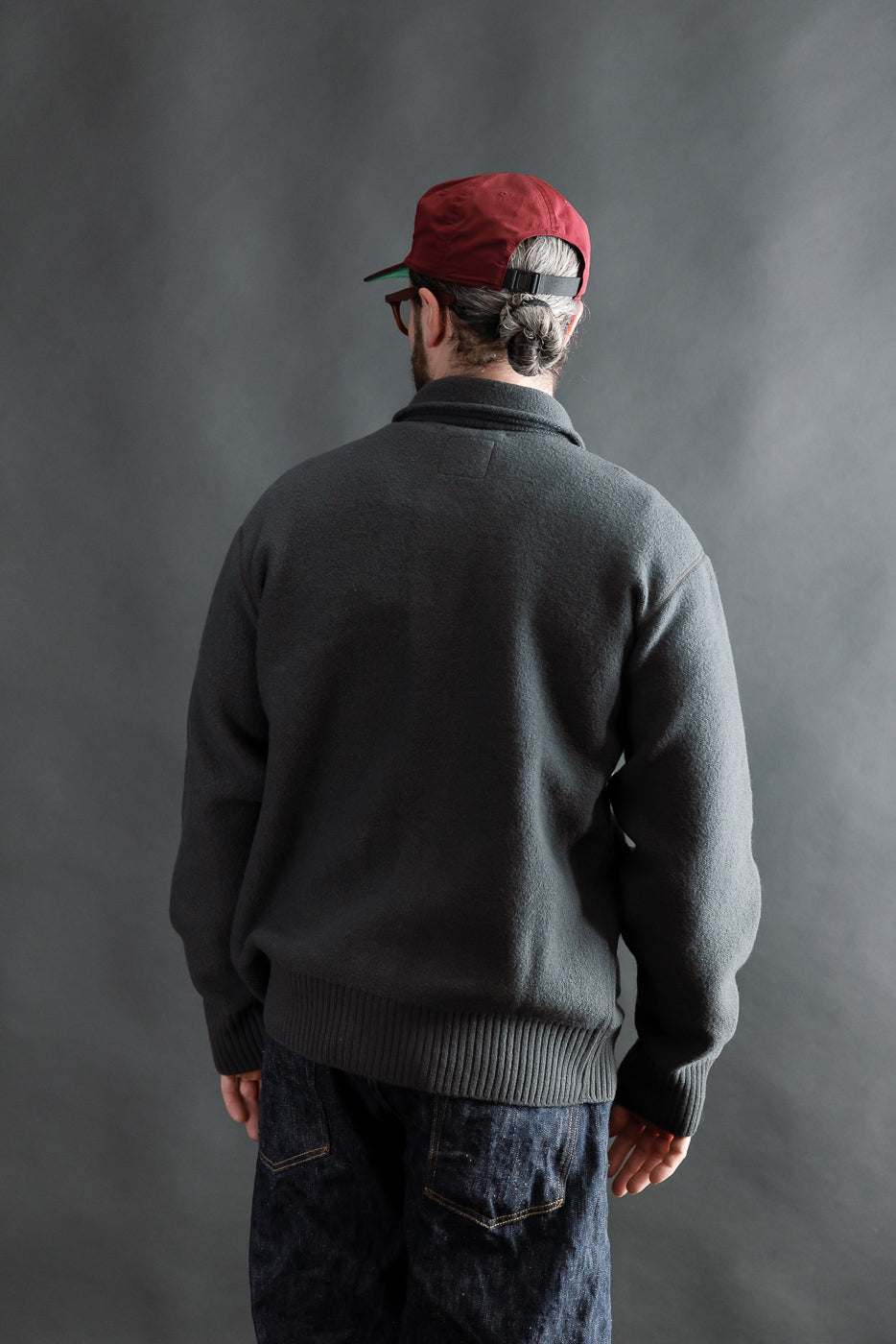 Male model 5'9, 165lbs, athletic build wearing Indigofera Brewster dark grey boiled wool shirt, back view full body