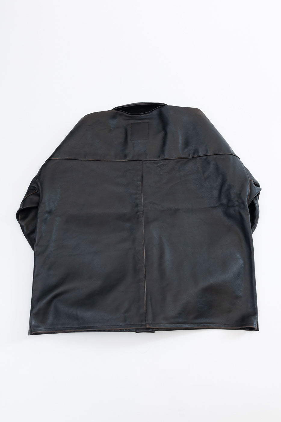 Back view of a dark brown leather jacket, flat lay.