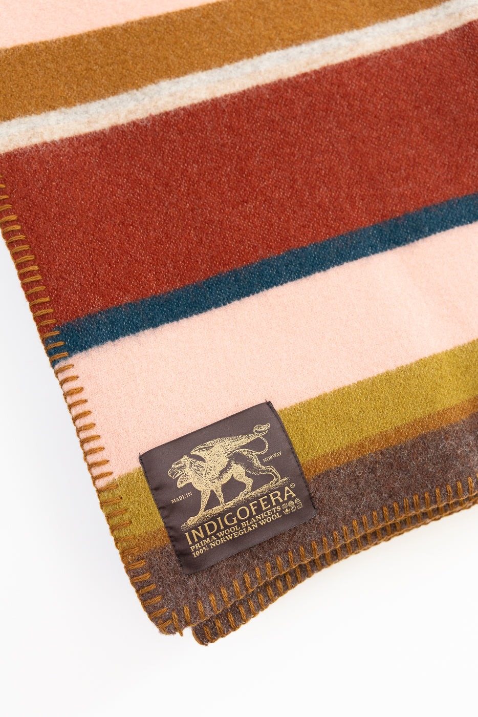 Striped wool blanket with an indigofera brand label on a white background