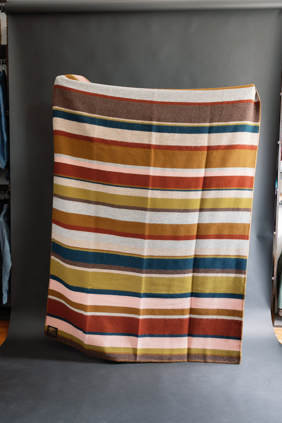 fully unfolded striped blanket against black background