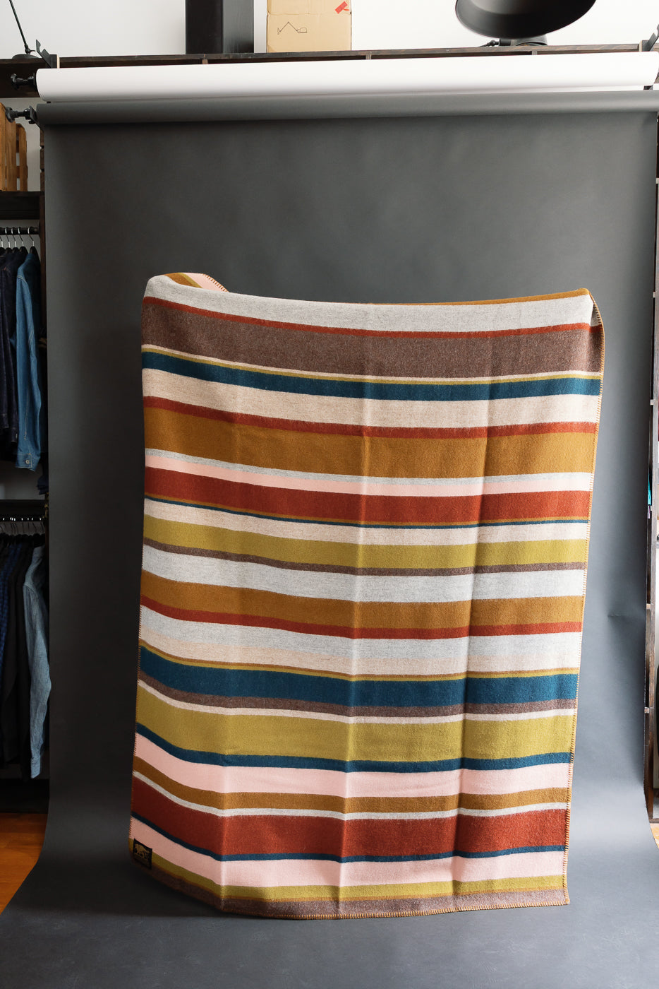 fully unfolded striped blanket against black background