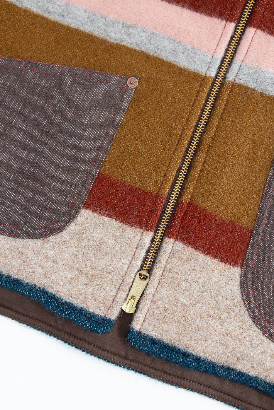 Close-up front view of striped wool jacket with gold zipper, contrast pocket, and hem detail