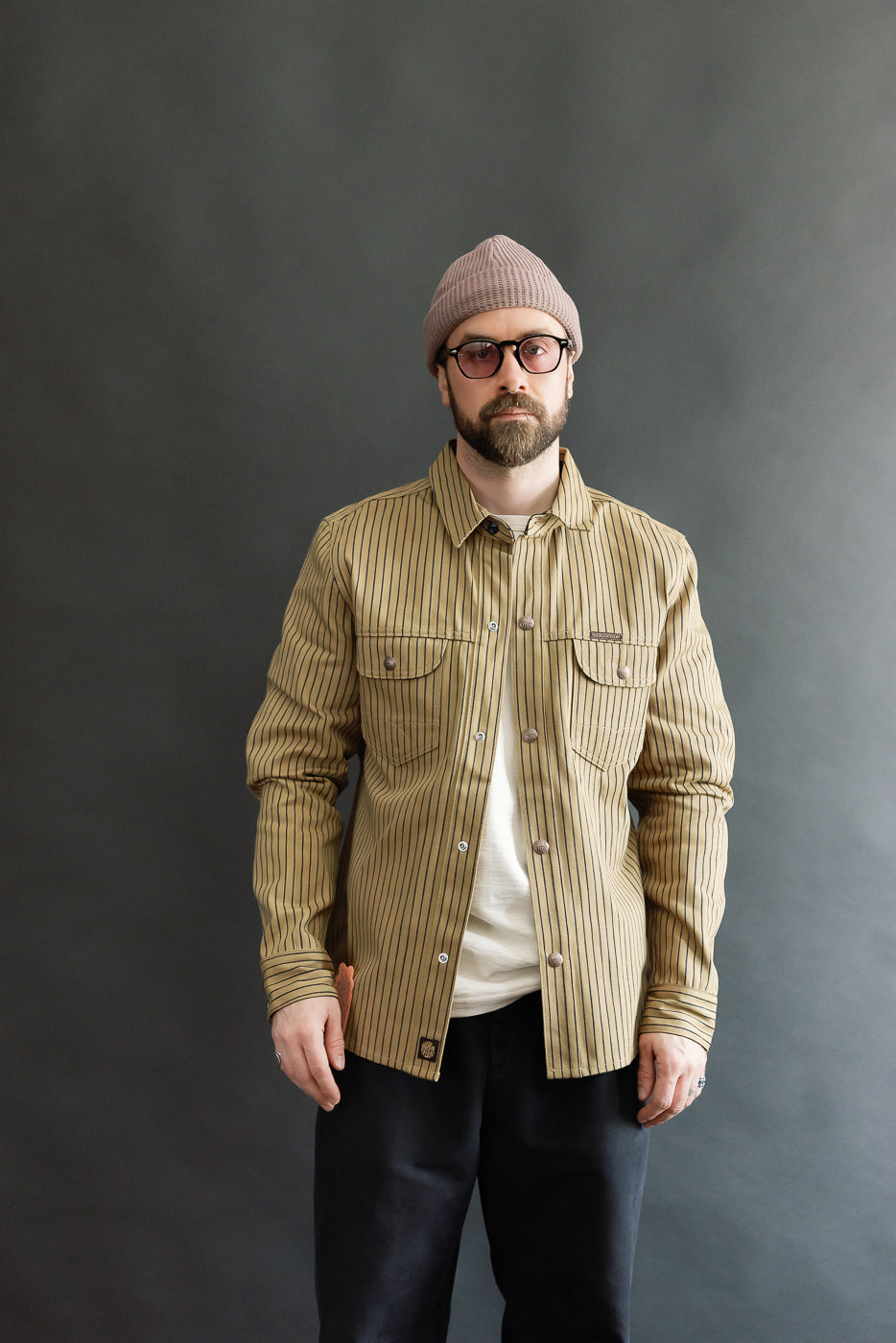 Front view, male model 5'9 165lbs athletic build, wearing beige indigo striped shirt jacket, full body.