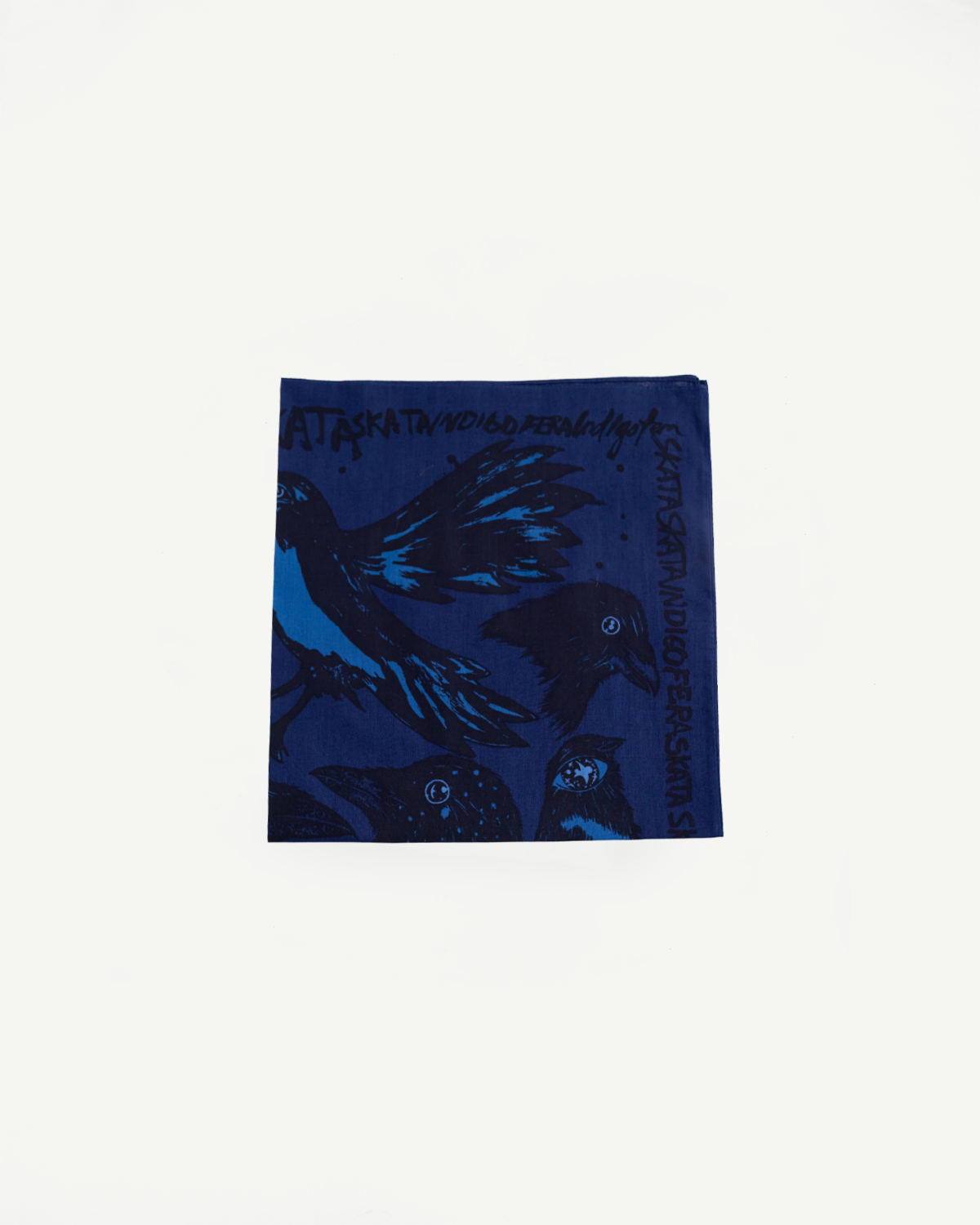 Flat lay front of Indigofera Devils Bird Bandana, blue-black cotton with bird illustration detail.