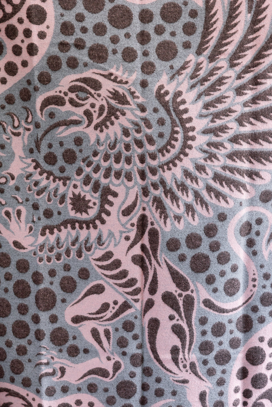 close up pink blanket with grypon, wings, and bubble pattern, back