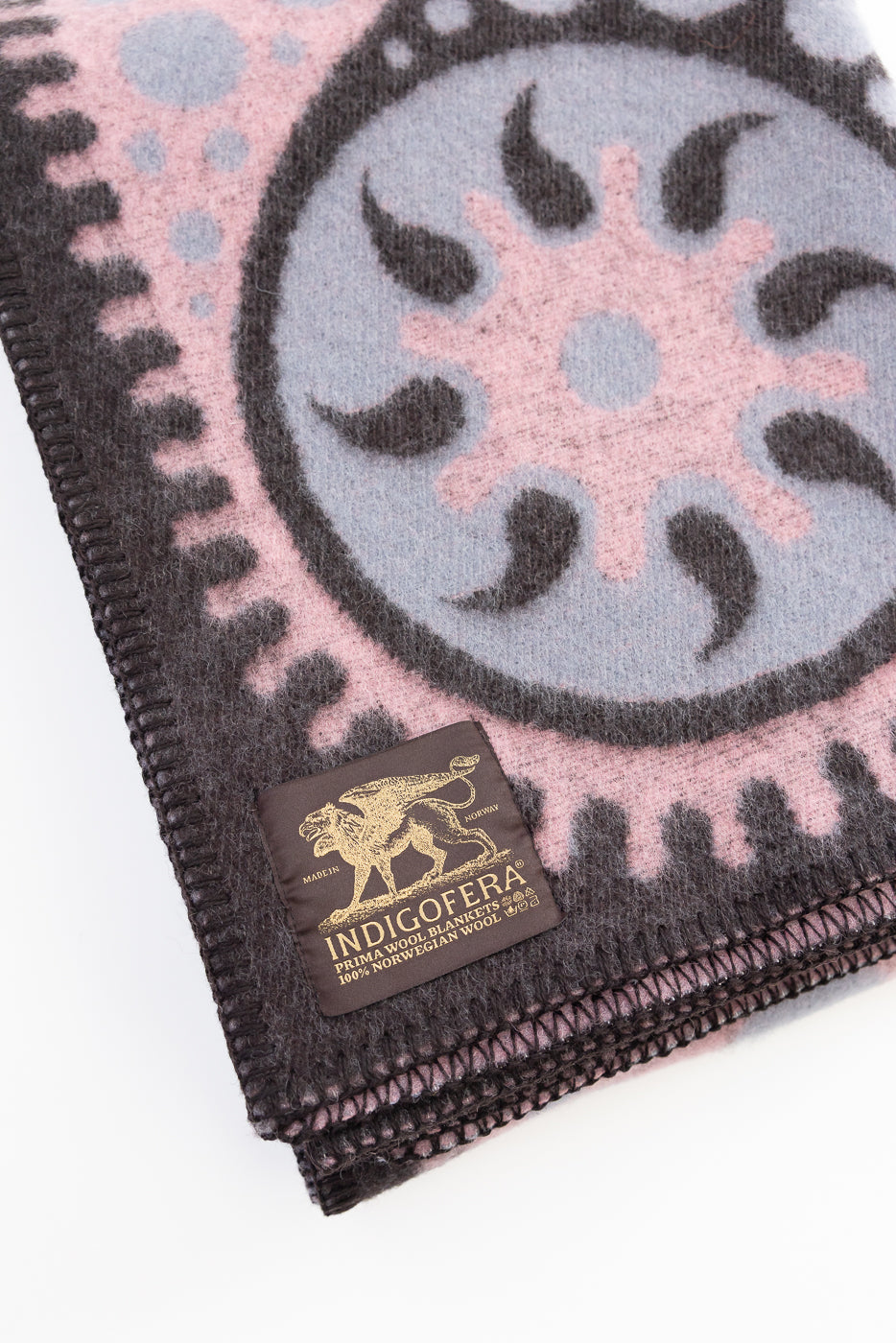 Close-up of a patterned fabric with a brand label on a white background