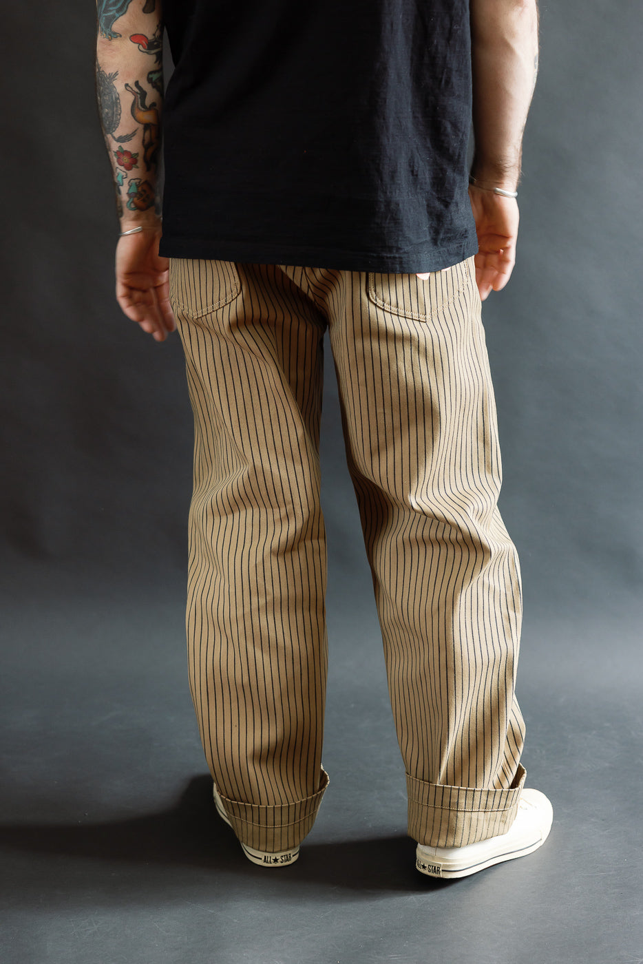 Back view, close-up of pinstripe beige pants on male model 5'9