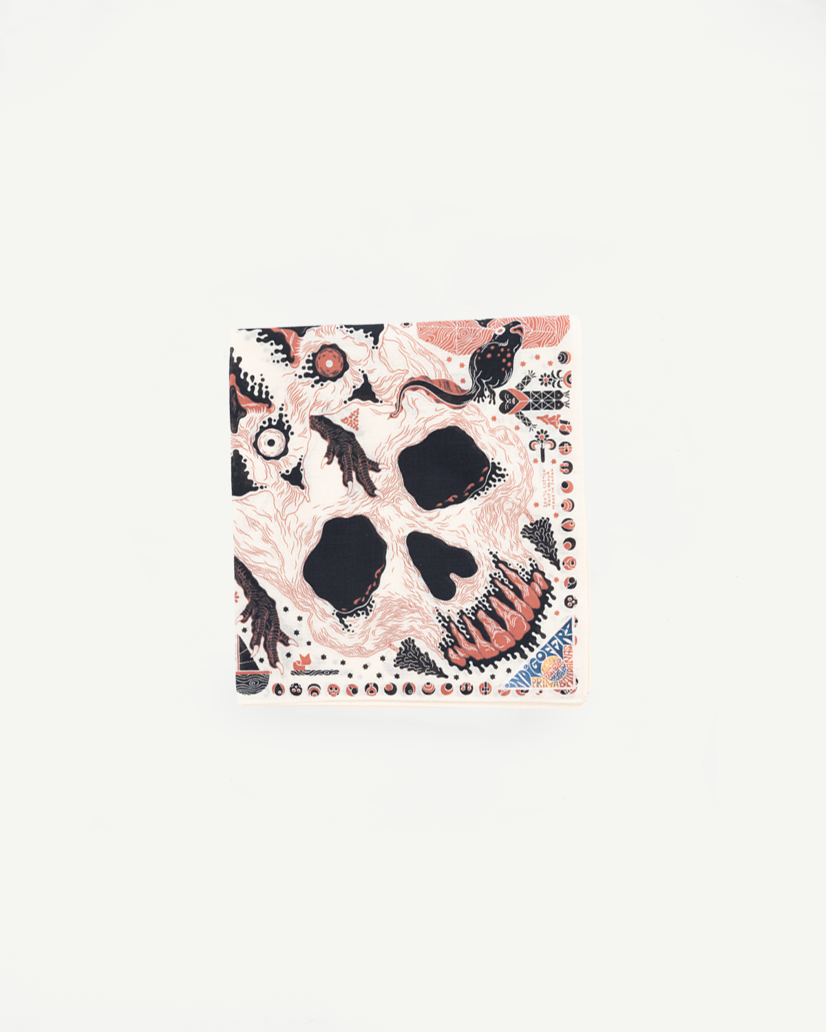 Flat lay close-up of a fabric accessory featuring a surreal skull illustration.