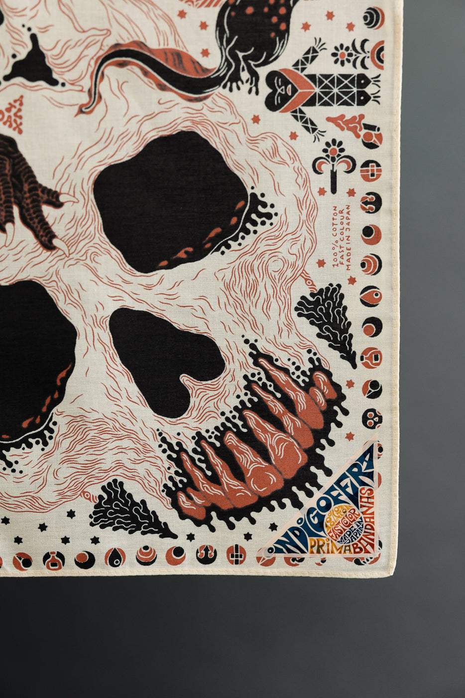 Close-up of a patterned fabric accessory featuring a skull and mystical illustrations.