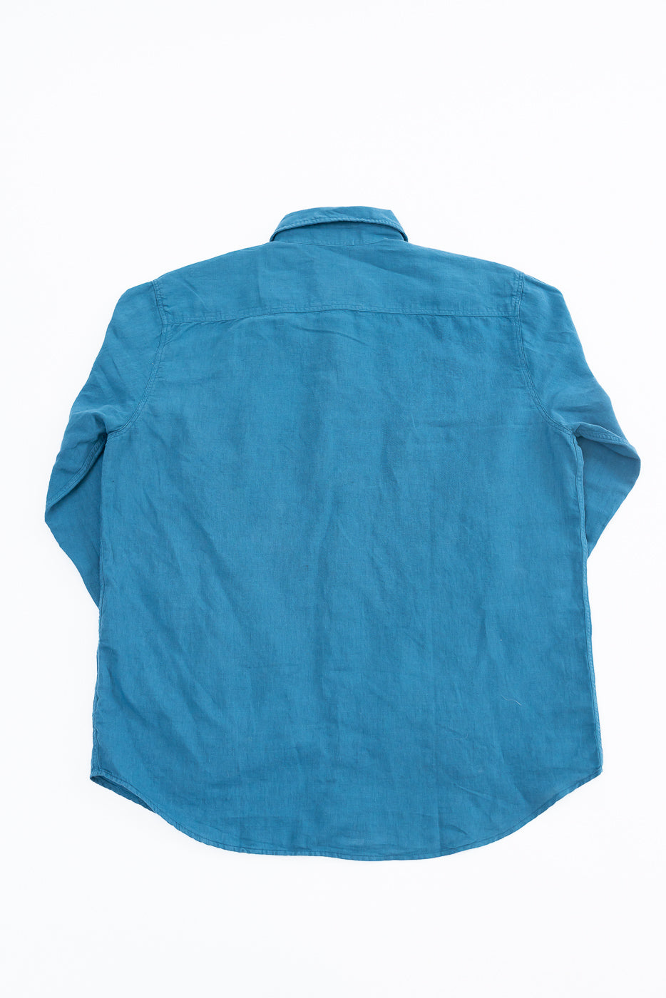 Flat lay of indigo blue canvas shirt, back view, showing full back, collar, and sleeve details.