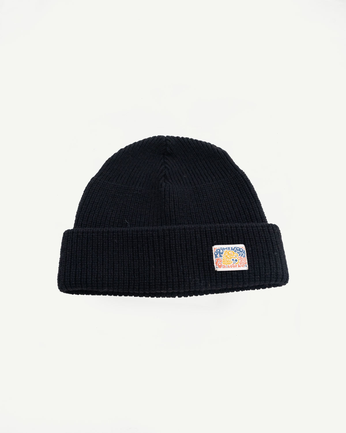 Front view close-up of a black ribbed knit beanie with a colorful graphic patch.