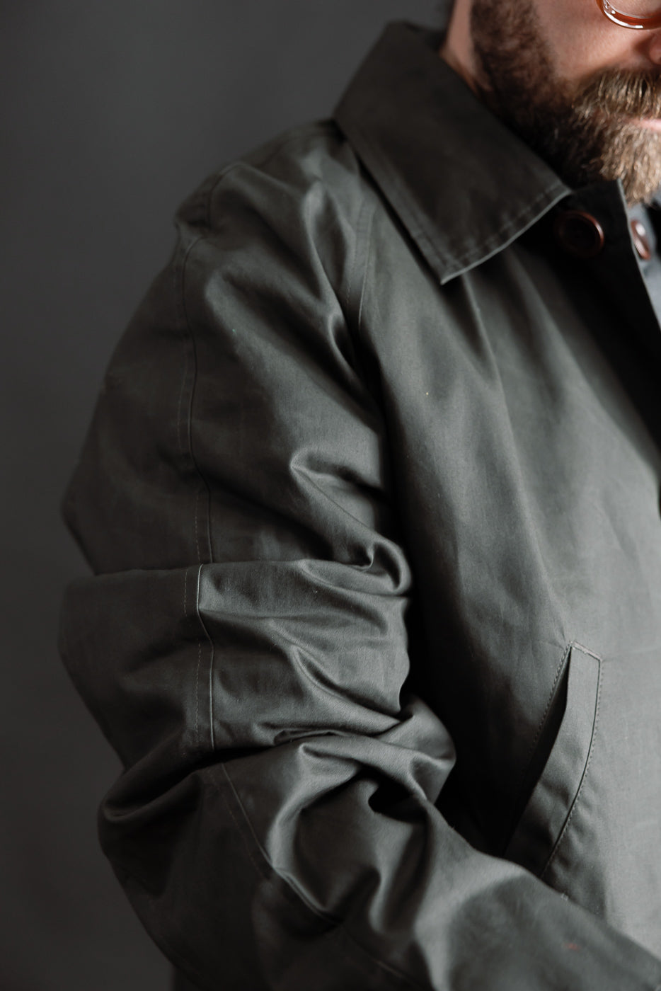 Close-up of Indigofera Raven Coat coated cotton twill dark grey, male model 5'9
