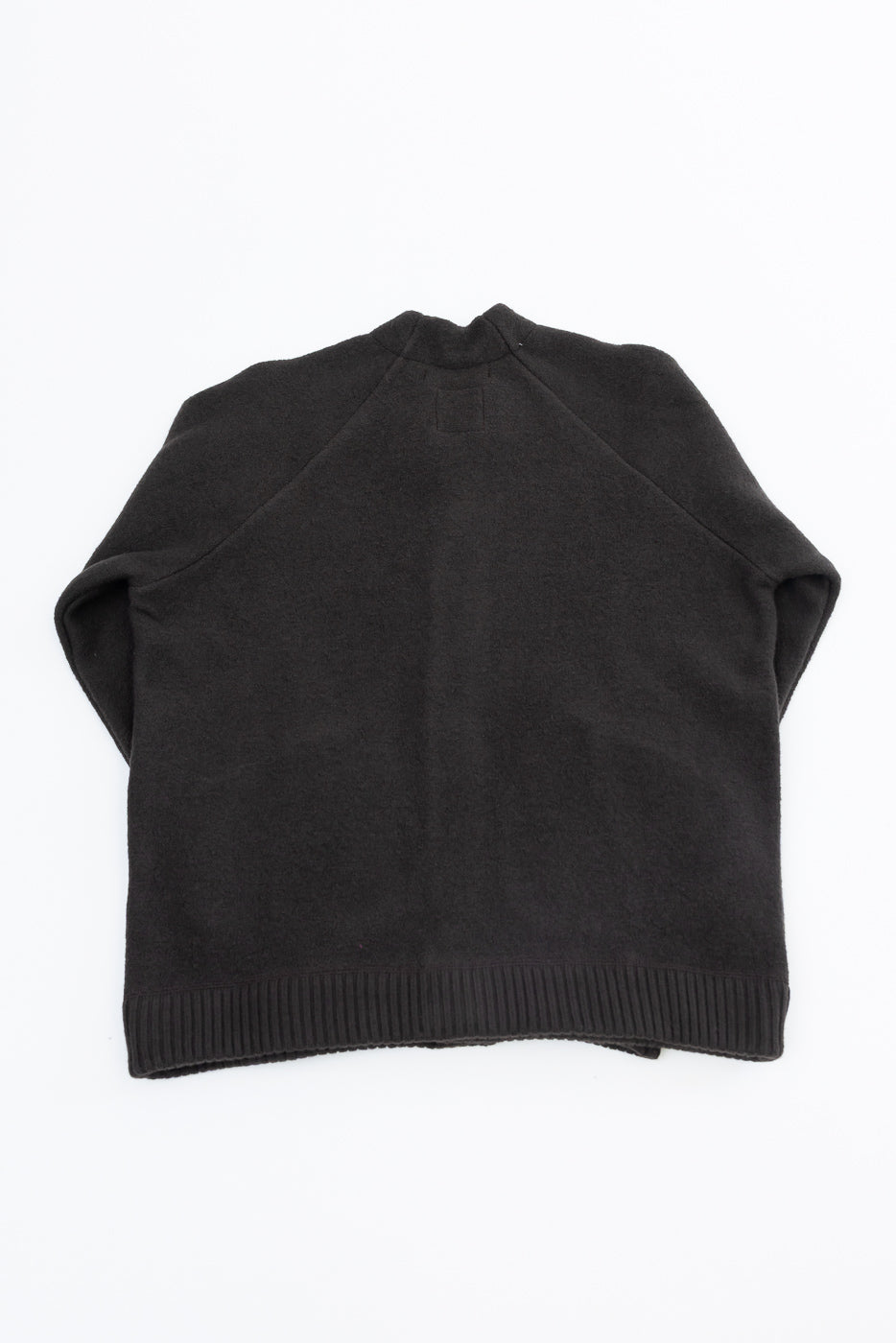 Back view flat lay of a black textured knit sweater with ribbed hem.