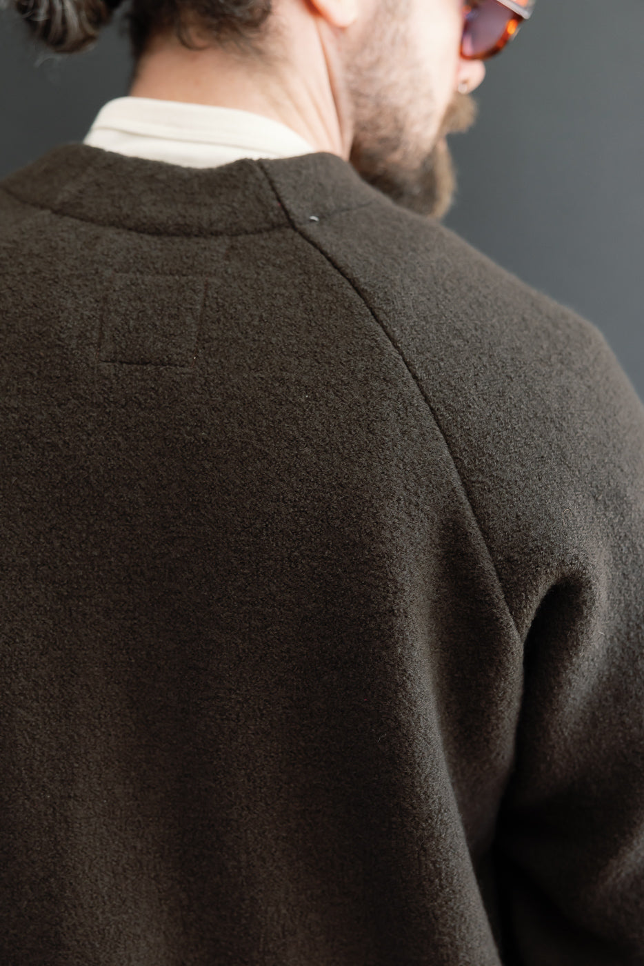 Close-up back view of a brown textured wool jacket on a male model, 5'9