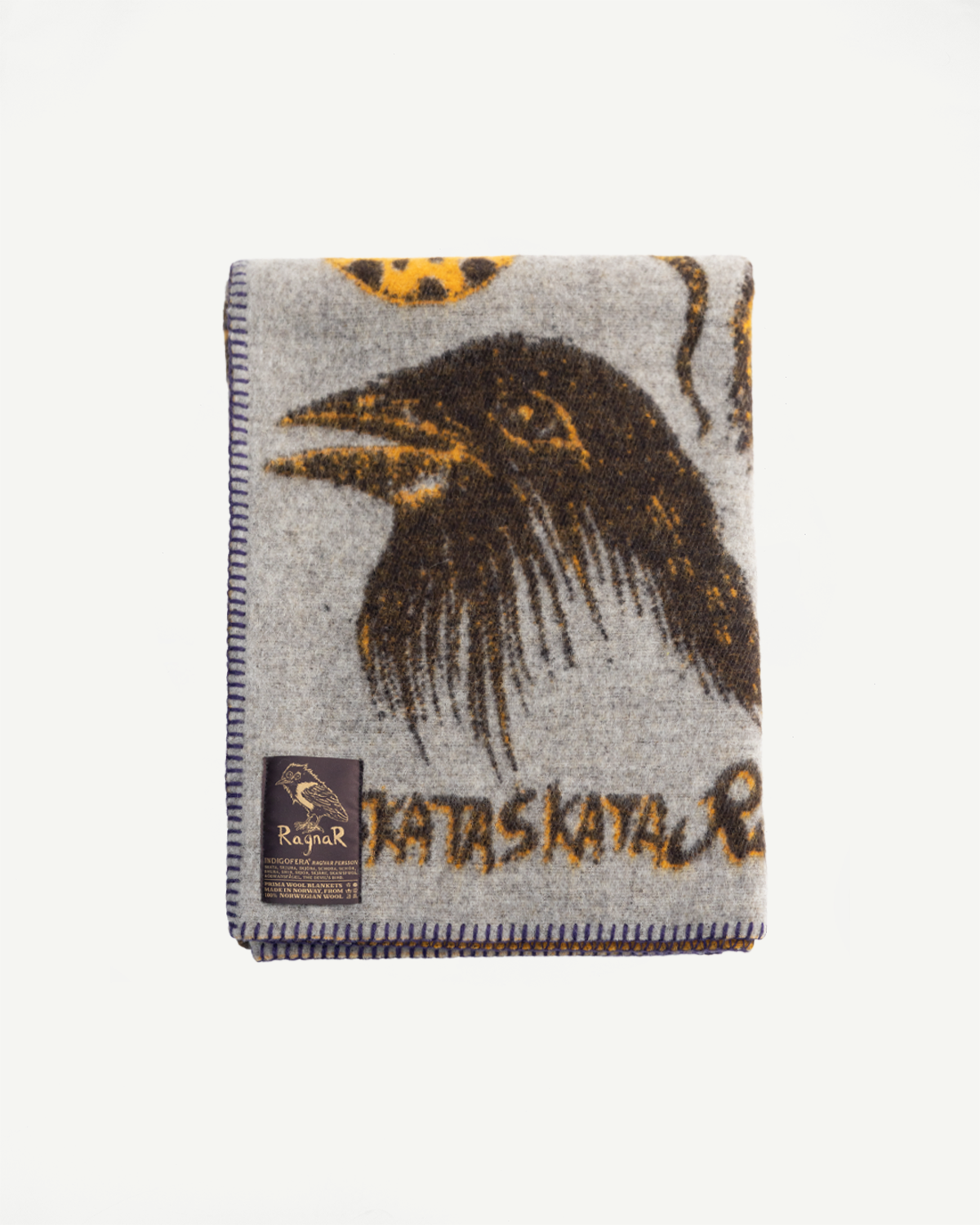 Indigofera Skata blanket front flat lay, grey brown yellow crow print, visible woven tag, Dant
