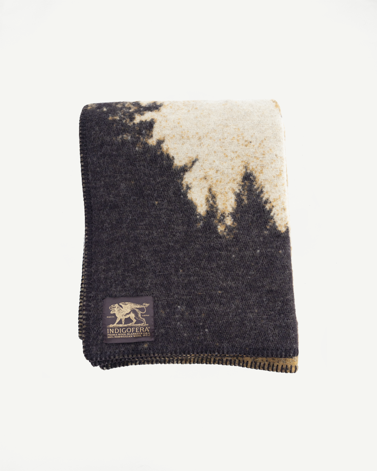 squared image of indigofera wool blanket with black trees and beige sky. indigofera tag at bottom left