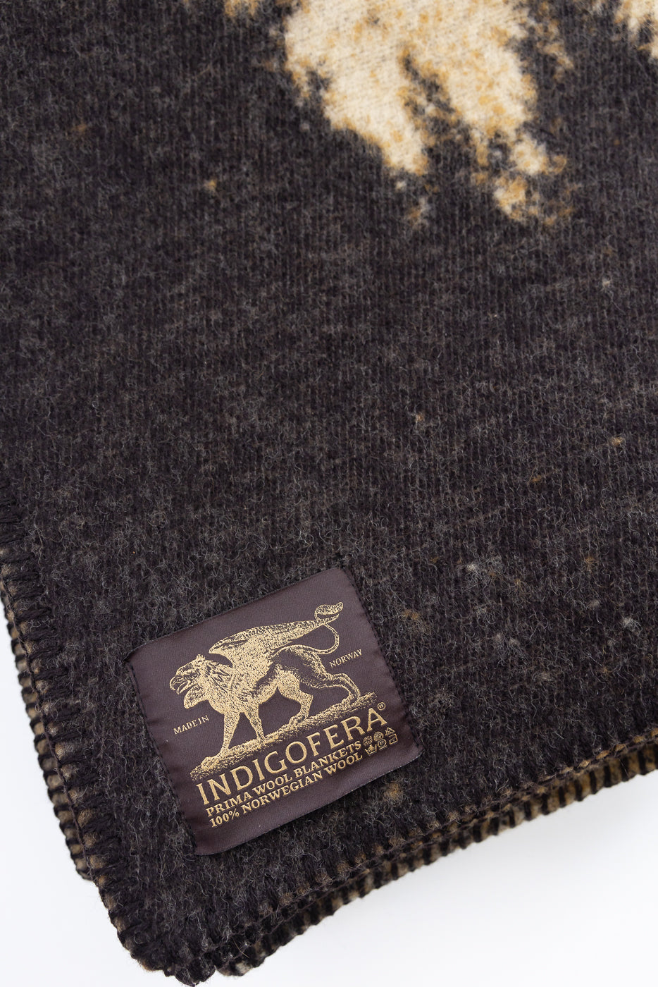 close up of indigofera satin blanket tag and whip stitched edge