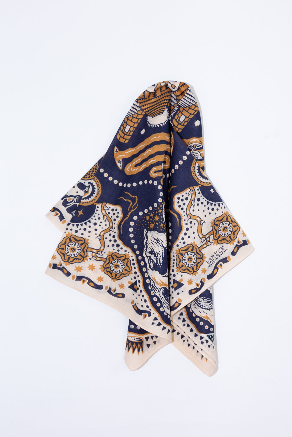 Front view of patterned bandana with navy, gold, and cream designs, featuring floral and abstract motifs on cotton fabric.