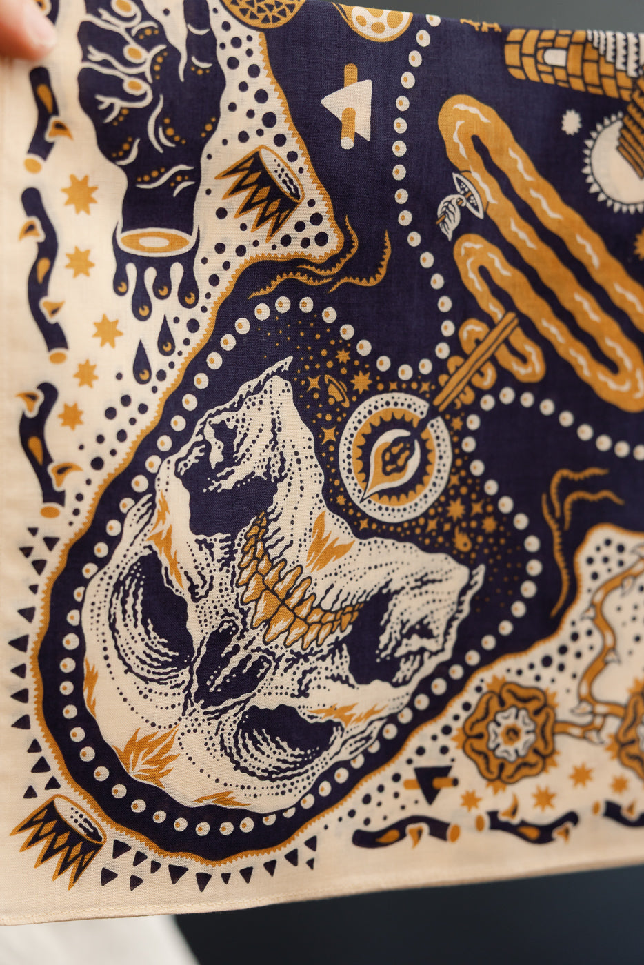 Close-up of skull and geometric pattern bandana, front view, navy and gold design