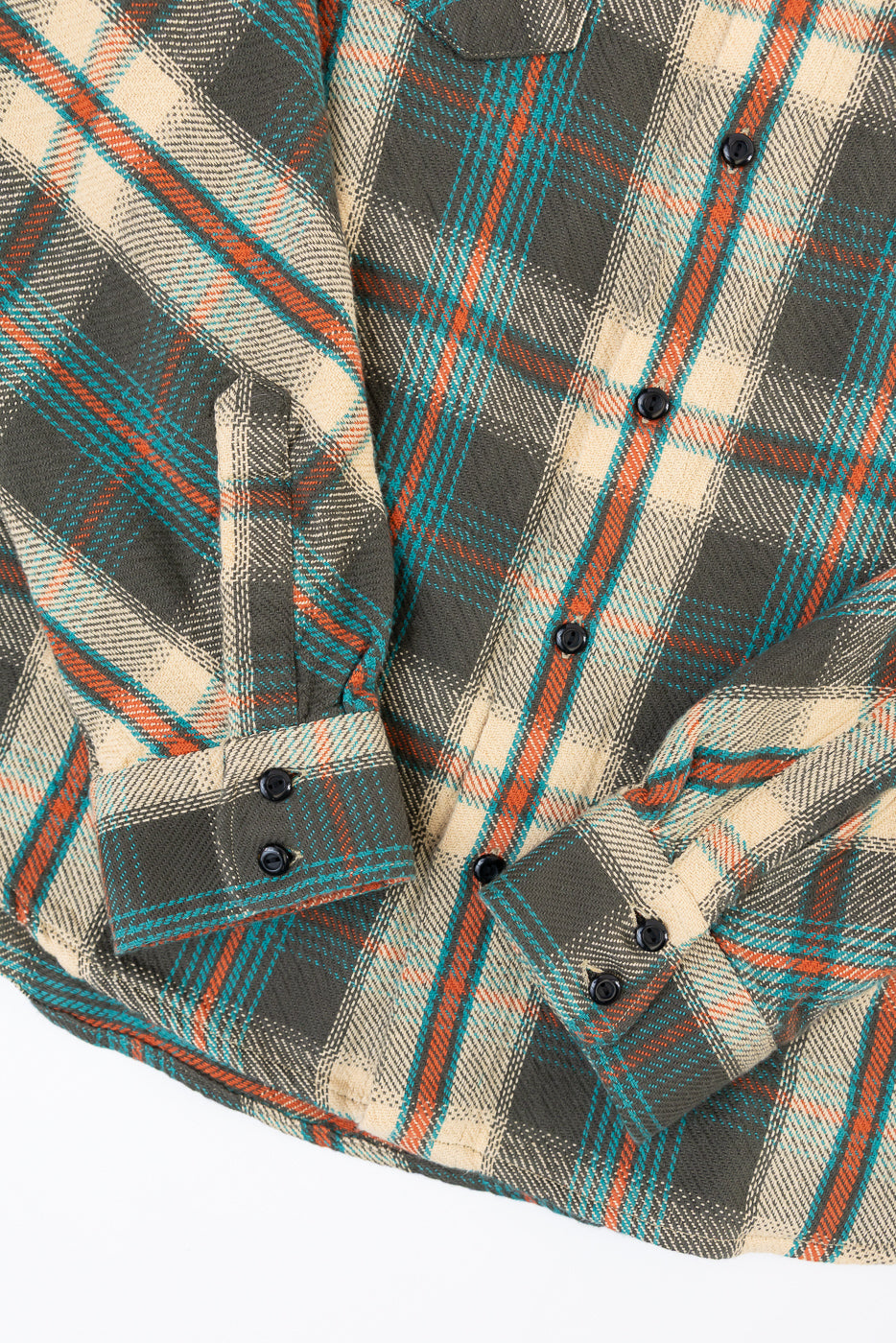 Flat lay front view of a plaid flannel shirt showing fabric texture and button details.