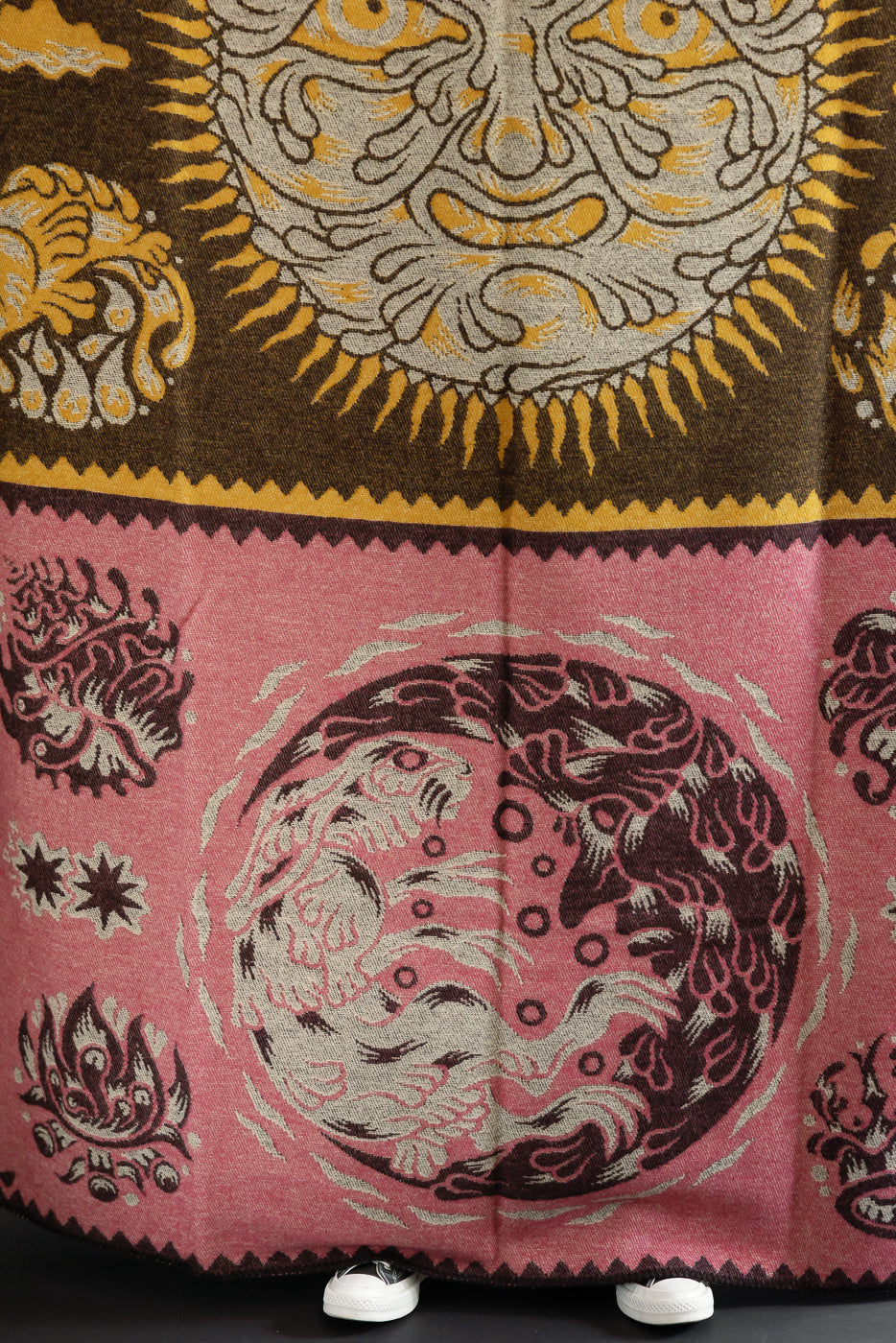 Close-up front view of a patterned textile featuring a sun motif and a circular moon design.