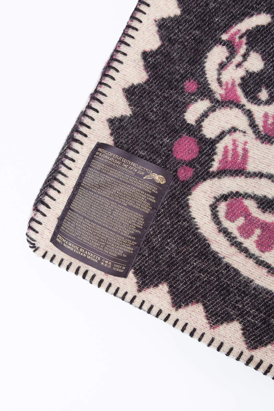 Close-up of the back of a wool blanket showing a detailed product information tag.
