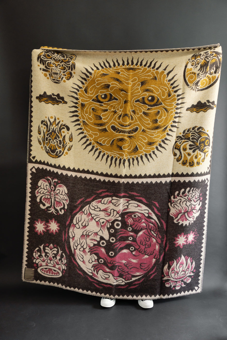 Full front view of a woven blanket featuring sun and moon celestial patterns.