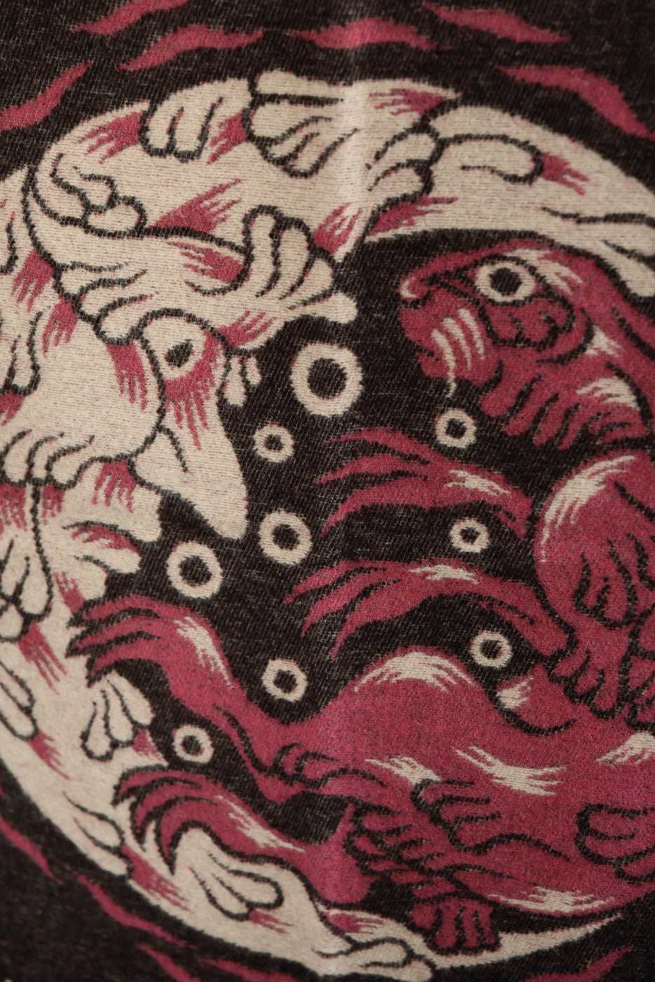 Close-up detail of a patterned fabric featuring a cream and maroon graphic design.