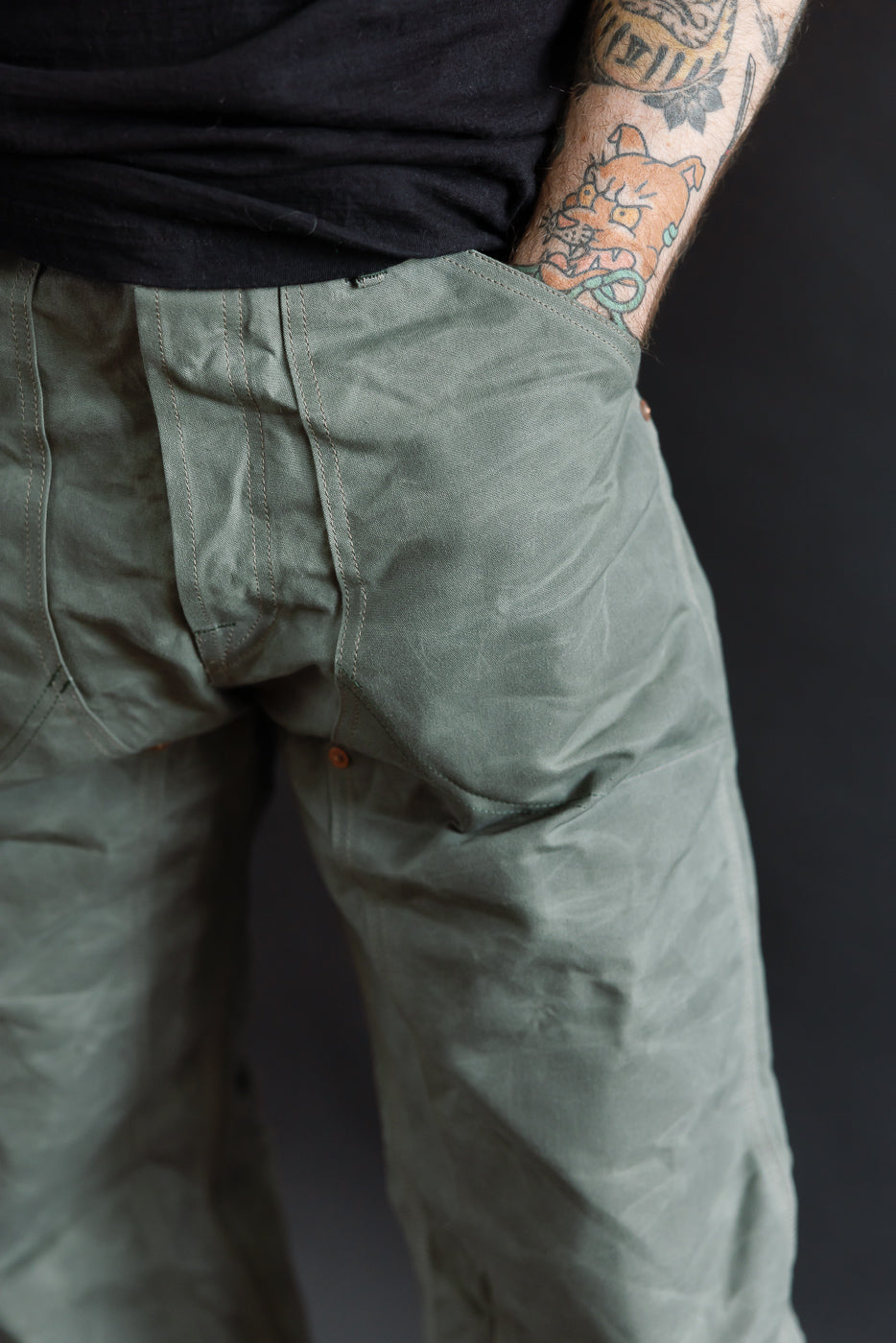 Close-up of back left side of double knee grey canvas pants on male model, 5'9