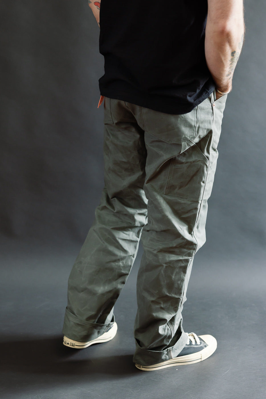 Full body rear view of grey coated canvas double knee pants on male model, 5'9